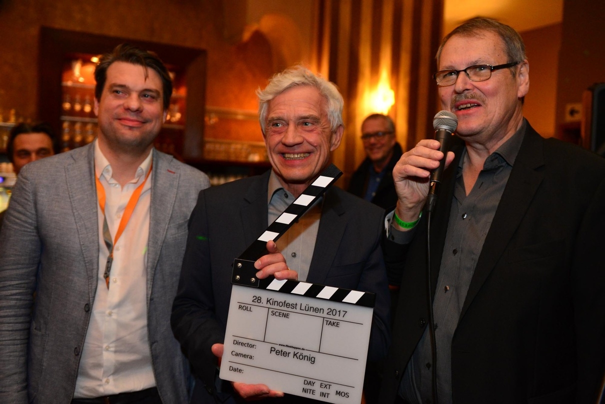Die Kinofest-Leiter Sven Ilgner (links im Bild) und Michael Wiedemann (rechts im Bild) überreichen die Ehrenklappe an Peter König