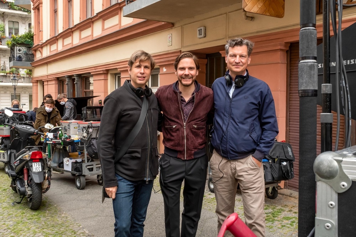 Produzent Malte Grunert (r.) am Set von "Nebenan" von Regisseur und Star Daniel Brühl (m.) sowie Drehbuchautor Daniel Kehlmann (l.)