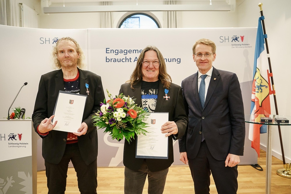 Erhielten die höchste Auszeichnung des Landes (von links): Holger Hübner und Thomas Jensen mit Ministerpräsident Daniel Günther