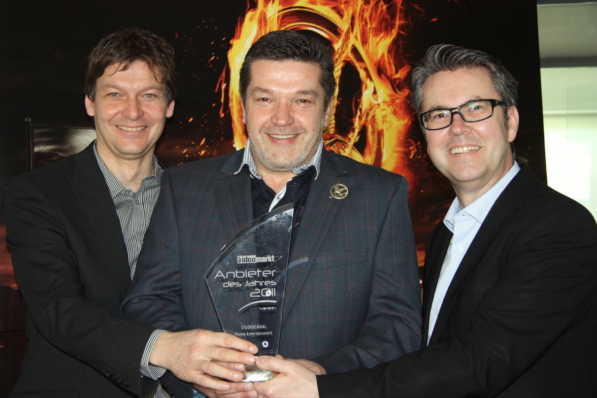 Uli Höcherl (Chefredakteur VideoMarkt, r.) überreichte den Preis für den Anbieter des Jahres Verleih an Jan Rickers (l.) und Hans Wenzke
