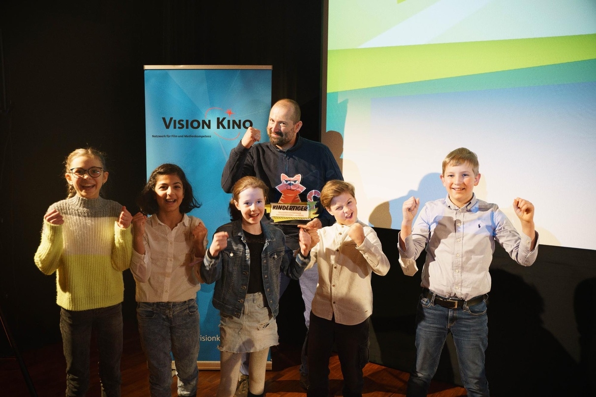 Bei der Verleihung des "Kindertiger 2021": Winfried Oelsner (Preisträger Kindertiger 2021, 3. v. r.) mit Frank Völkert (stellvertretender Vorstand der FFA, r.) und Leopold Grün (Geschäftsführer VISION KINO, 2. v. r.) sowie der FBW-JUGEND FILMJURY, der KiKA-Jury und den Nominierten Stefan Westerwelle (l.), Hanna Schweier (2. v.l.) und Dirk Ahner (3.v.l.)