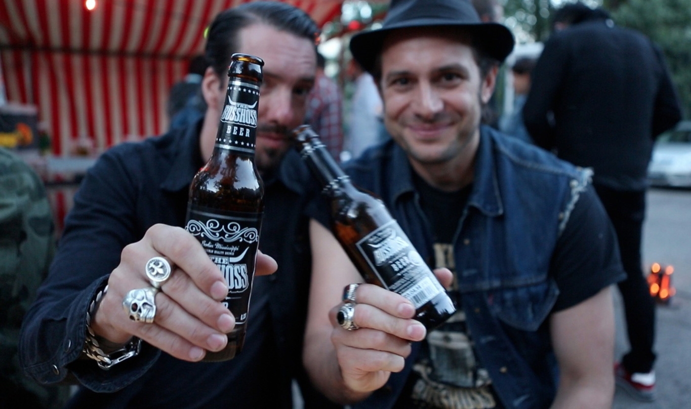 Kennen sich in Sachen Marketing aus: Alec Völkel (links) und Sascha Vollmer von The BossHoss, die hier mit ihrem eigenen Bier anstoßen