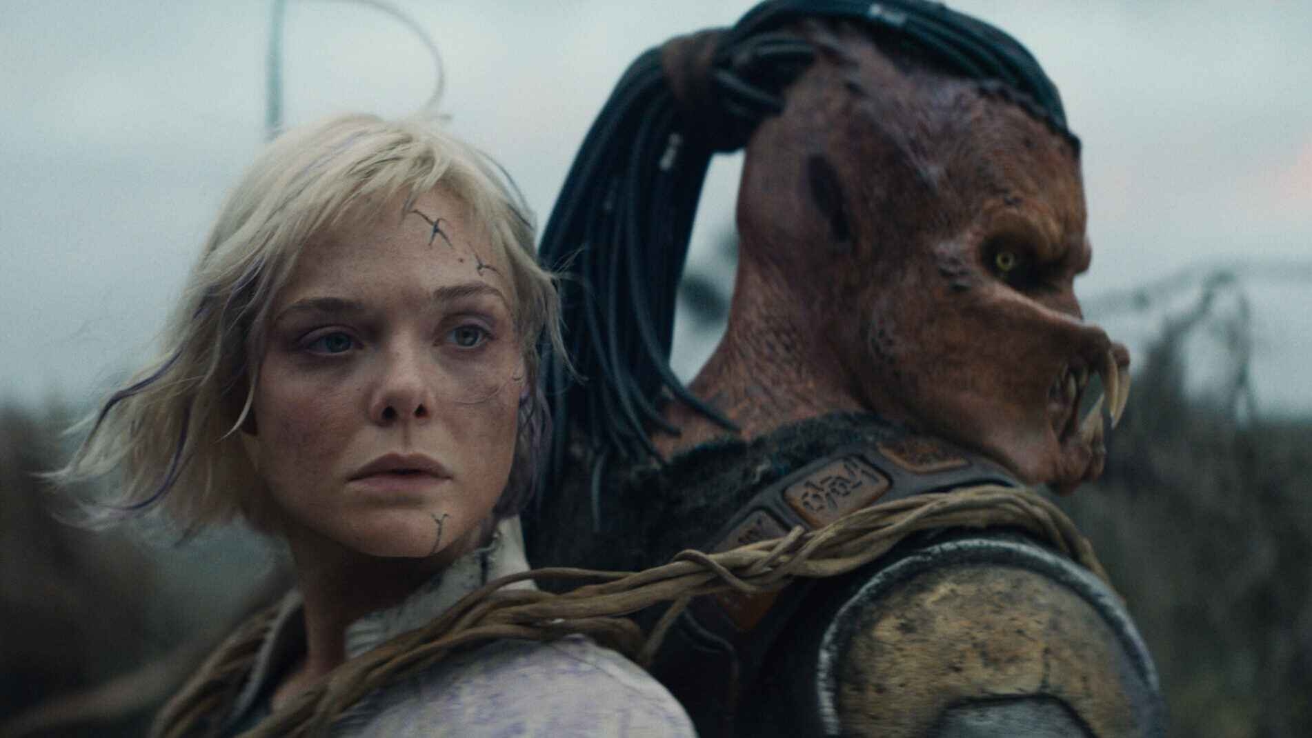 (L-R) Thia (Elle Fanning) and Dek (Dimitrius Schuster-Koloamatangi) in 20th Century Studios' PREDATOR: BADLANDS film. Photo courtesy of 20th Century Studios. © 2025 20th Century Studios. All Rights Reserved.