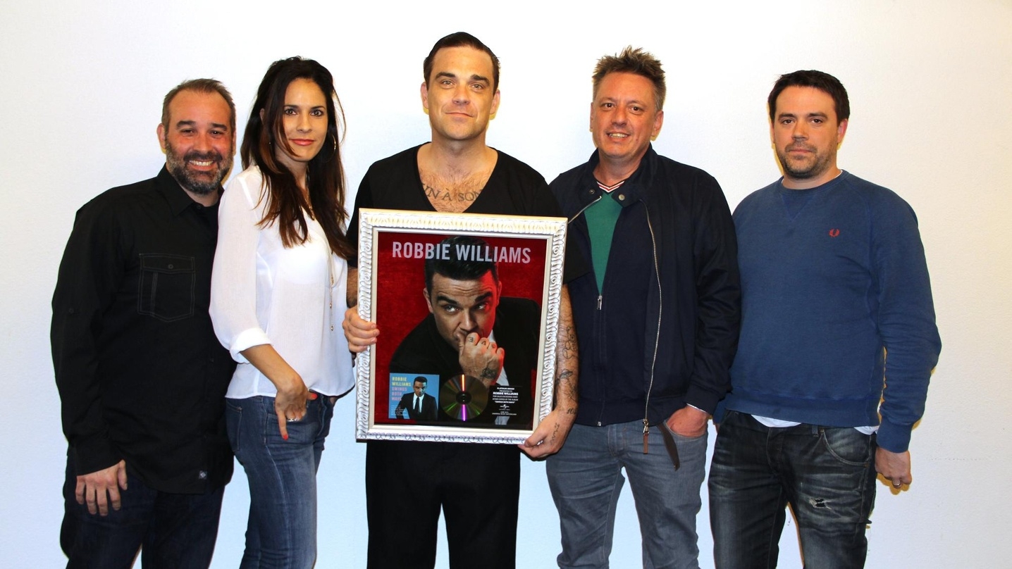 Vergrößerte seine Edelmetallsammlung: Robbie Williams (Mitte) und seine Gratulanten von Universal Music