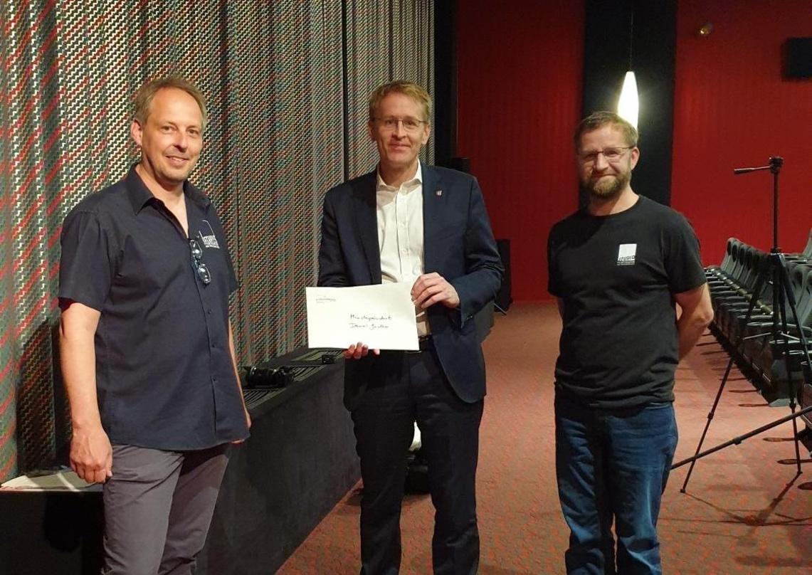 Dennis Jahnke und Matthias Ehr vom Kieler Studio Filmtheater am Dreiecksplatz übergaben den Brief an Ministerpräsident Daniel Günther