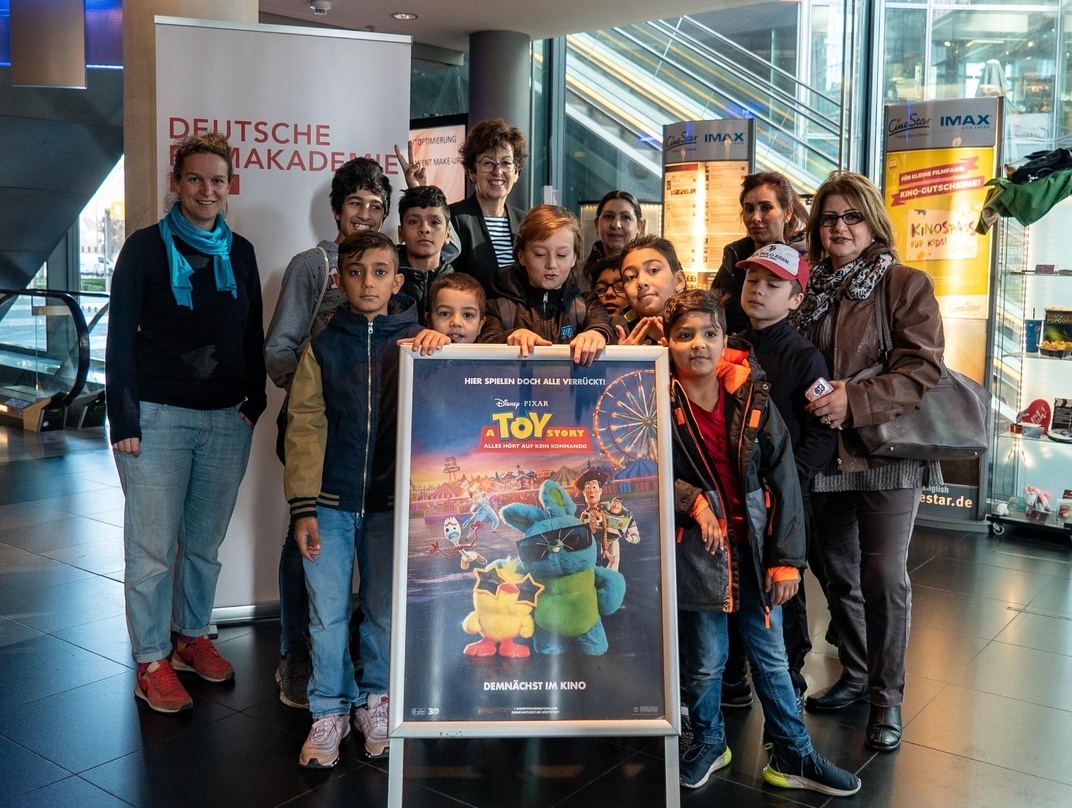 Filmakademie-Geschäftsführerin Maria Köpf (hinten, Mitte) mit einigen Gästen von "Kino für Geflüchtete"